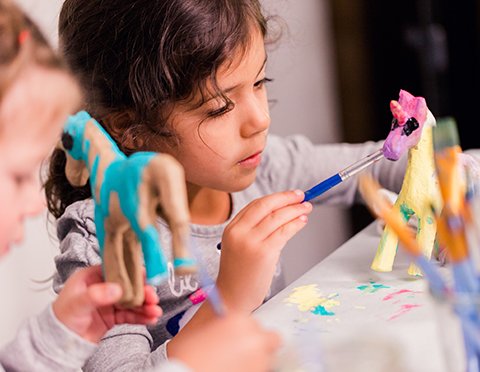 Child exploring hands-on STEAM creativity through painting